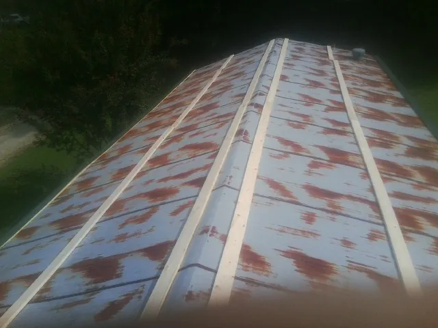 Rusted metal roof panels with new wood purlins before replacement — Storm Damage Roof Repair in Jordan by Roofing Brothers