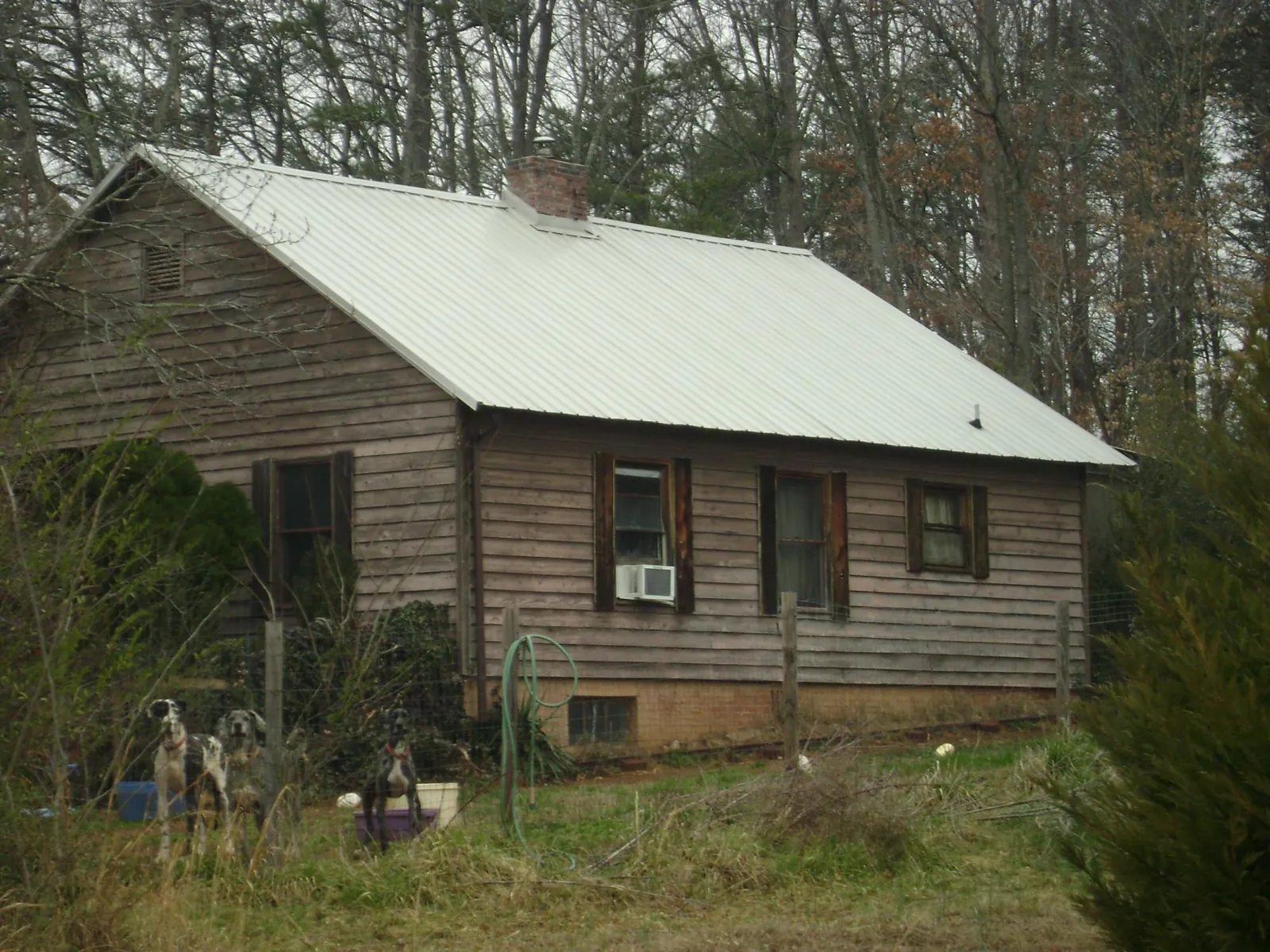 White metal roof on an old wood sided farmhouse, from a Asphalt Shingle Roof Repair job in Jordan